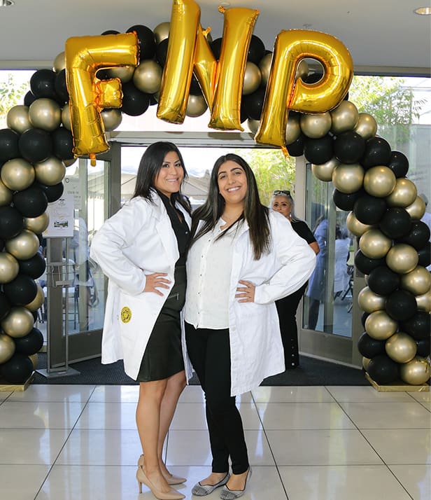 student with FNP balloons after white coat ceremony