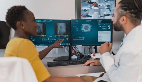 Two students review radiology scans at a computer