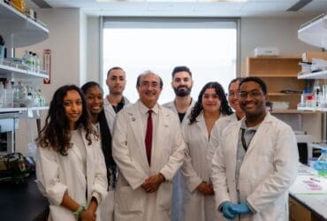 Group photos of students in white coats standing in the lab