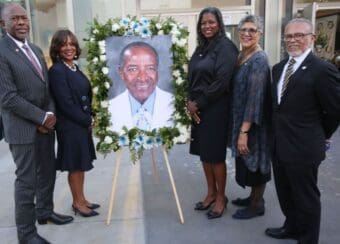 Group photo of representatives from the four historically black medical colleges with a photo of Dr. Parrott