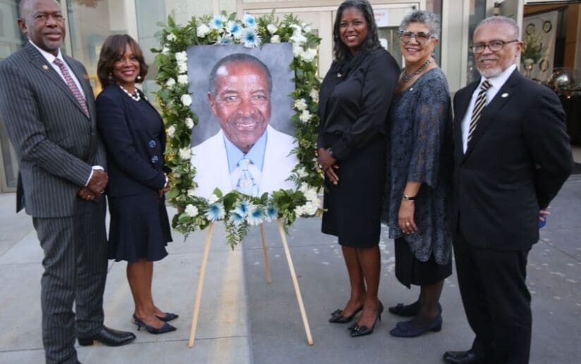 Group photo of representatives from the four historically black medical colleges with a photo of Dr. Parrott