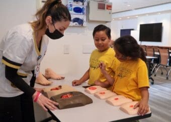 cdu nursing student goes over medical procedures with two pipeline students