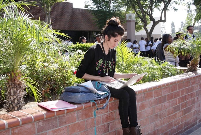 Woman sitting on brick wall
