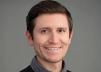 man wearing collared shirt and sweater