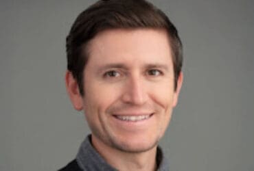 man wearing collared shirt and sweater