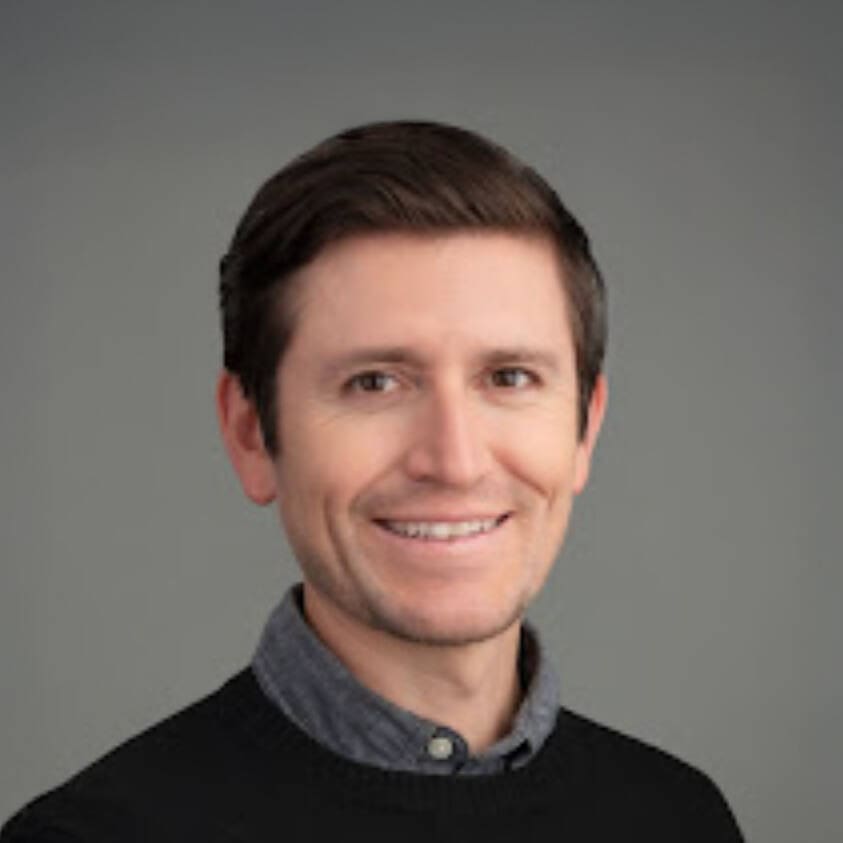 man wearing collared shirt and sweater