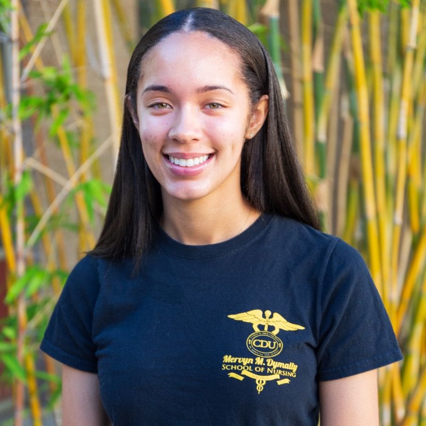 Student standing in front of bamboo