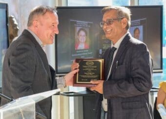 Faculty members holding plaque