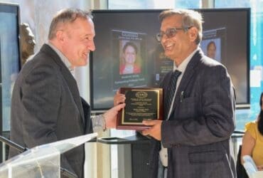 Faculty members holding plaque