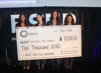 students holding large check
